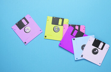 Many colored floppy disks on blue background. Computer technology 80s. Top view.