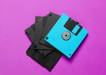 Stack of black and pink floppy disk on a pink background