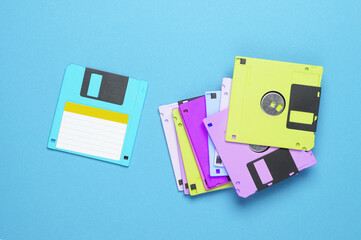 Many colored floppy disks on blue background. Computer technology 80s. Top view.