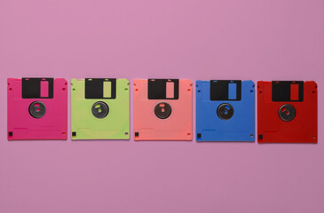 Set of colored floppy disks on a pink background
