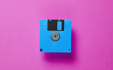 Floppy disk on pink background. Retro technology. Top view