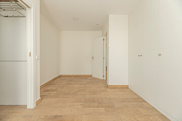 Undecorated guest room with eco-designed white wardrobes, FSC-certified wood, and non-toxic...