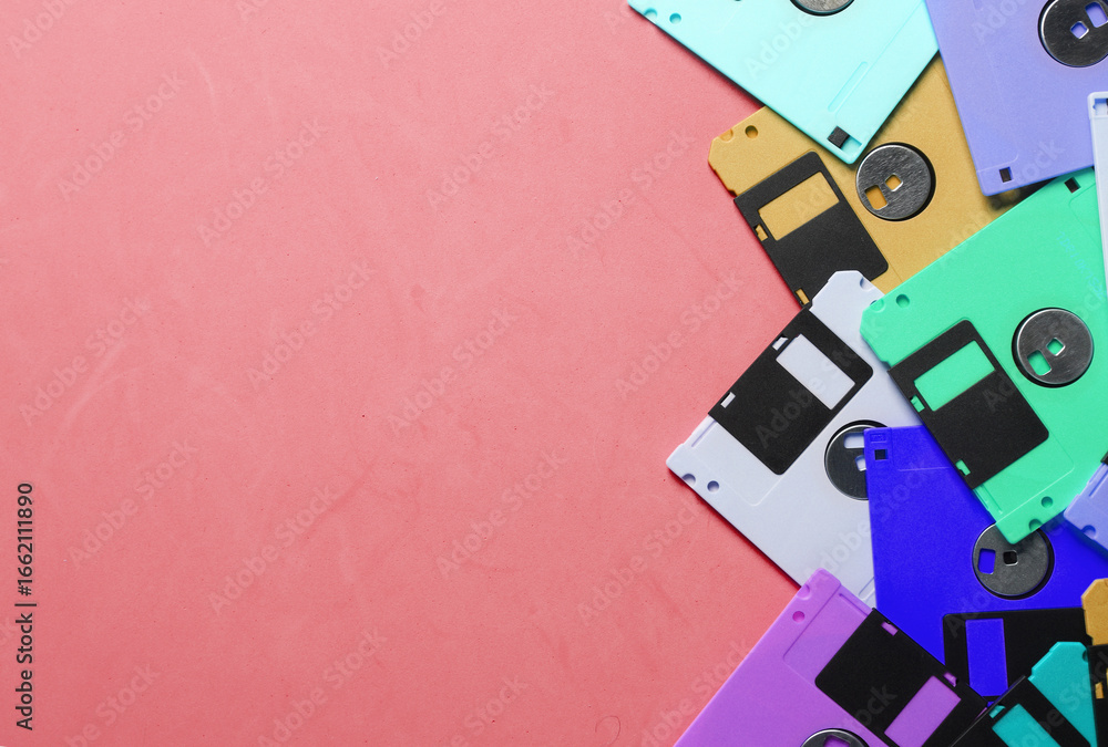 Poster Colored floppy disks on pink background. Retro technology. Top view. Copy space