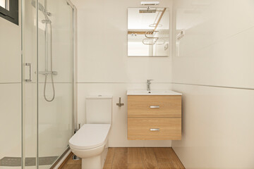 Storage solution in a small bathroom:  wood wall-mounted vanity unit with spacious drawers and a...