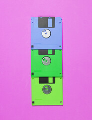 Colored floppy disks on a pink vivid background. Top view