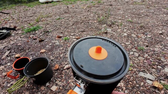 A vibrant camping scene with a pot boiling water over a reliable heat source, perfect for outdoor cooking fans who value practicality and efficiency while appreciating natures beauty
