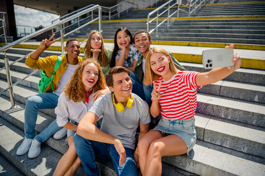 Group of young friends taking a selfie together outdoors on a summer day showcasing joy and global friendship