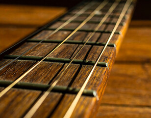 Close-up view of a weathered acoustic guitar neck with strings and frets.