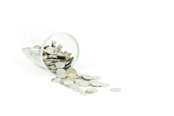 Coins spilling from a glass jar symbolize financial crisis, money loss, debt, and recession,...