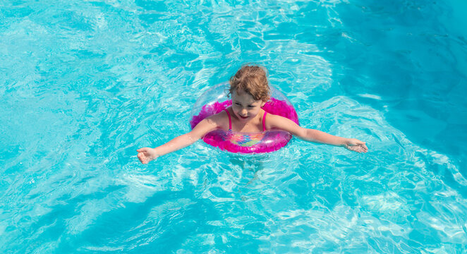 Child swimming in a pool with a ring. Selective focus.
