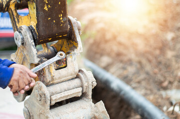 The mechanic is using a wrench to tighten a nut for maintenance.