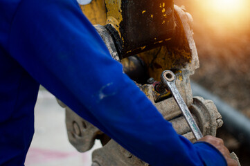 The mechanic is using a wrench to tighten a nut for maintenance.
