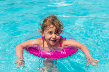 Child swimming in a pool with a ring. Selective focus.