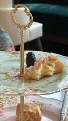 Elegant high tea arrangement with scone and pastry on floral stand for cafes and bakeries, concept...