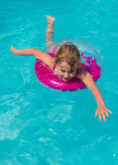 Child swimming in a pool with a ring. Selective focus.