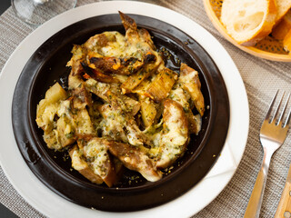 Portion of just cooked stuffed eggplant served on plate in restaurant.