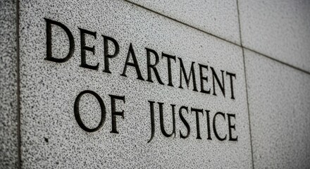 Department of Justice" engraved in grey, stone-like wall, close up