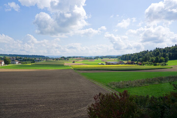 High angle view of scenic rural landscape with Swiss village of Dinhard in the background seen through train window on a sunny summer noon. Photo taken August 22nd, 2025, Zurich Dinhard, Switzerland.