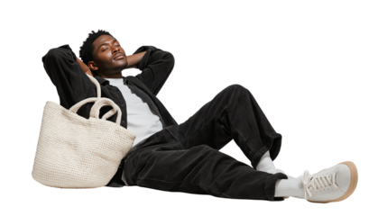 Relaxed young man resting, tote bag on floor, isolated PNG background