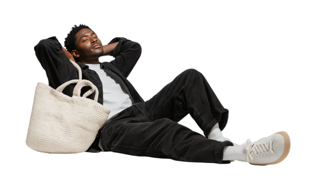 Relaxed young man resting, tote bag on floor, isolated PNG background