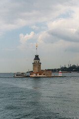 Obraz premium Historic lighthouse tower with ferry on Bosphorus waters in Istanbul