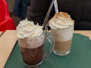 Delicious hot chocolate and latte with whipped cream for a cozy cafe experience