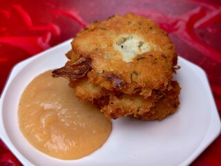 Delicious potato latkes stacked high with applesauce on a white plate for hanukkah