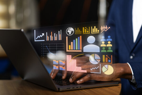 African financial analyst working on a laptop with a projected virtual dashboard, compiling a detailed report on corporate growth, sales figures, and global analytics.