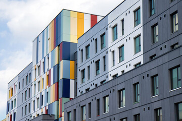 New construction apartment building featuring colourful vertical cladding panels, nobody