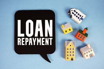 Loan Repayment text with house models on blue background