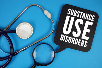 Substance Use Disorders  text with Stethoscope and magnifying glass on blue background