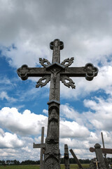 Old wooden cross on cloudy blue sky background