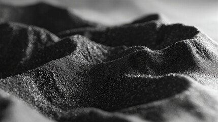 Macro close-up of textured black granular surface with sparkling highlights forming small dunes in 4K resolution