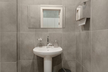 Bathroom in gray and white tones with dim lighting