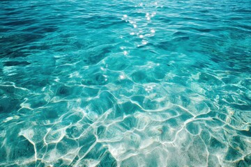 Clear turquoise water with sunlight reflecting off the gentle surface, creating shimmering patterns on the sandy seabed below