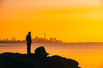 Toronto skyline in the morning. Silhouette figure of a man enjoying the Toronto sunrise
