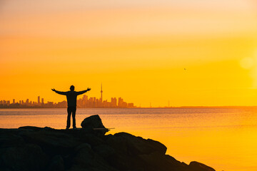Toronto skyline in the morning. Silhouette figure of a man enjoying the Toronto sunrise