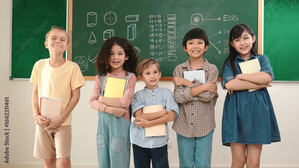 Poster multicultural elementary student in casual cloth looking at camera while standing at classroom. grou