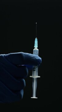 an anesthesiologist with a syringe in his hands and wearing sterile gloves is about to administer a dose of medicine to a patient before surgery.
A dose of medicine in a syringe at a doctor