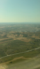 Scenic aerial view of countryside fields under blue sky - agriculture, travel, real estate businesses concept