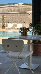 Relaxing poolside dining with empty table and chairs set for two at scenic outdoor resort café - concept of hospitality, tourism, hospitality, and event planning
