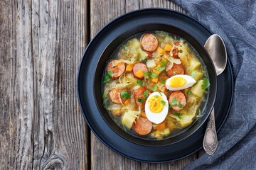 Polish sauerkraut soup with sausage in a bowl