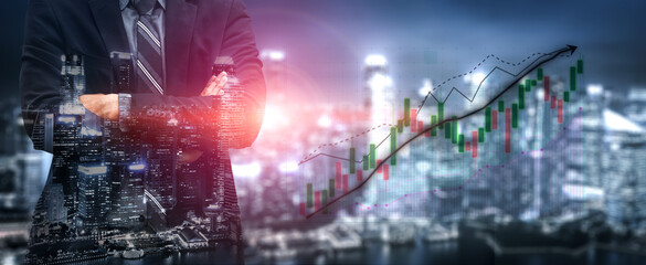 Obraz premium A focused businessman stands confidently with crossed arms, juxtaposed against a dynamic city skyline and stock market graph, symbolizing financial ambition. Impute