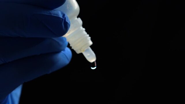 Doctor in blue gloves holds a bottle of eye drops.
Treatment of poor grain and dry eyes.
Dry eyes from sitting at a laptop for a long time.
Ophthalmology concept