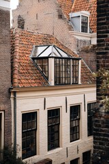 Charming architectural details of a historic building with a glass-roofed extension in a Dutch town during early morning light