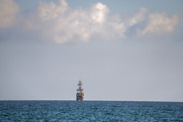 Old sailing ship on the horizon over the sea