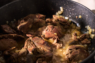 Cooking liver in a frying pan with herbs and spices for a savory dish