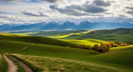 Rolling green hills and snowcapped mountains under a cloudy sky