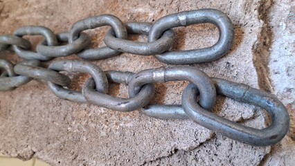 Close-up of a heavy-duty chain against a textured surface