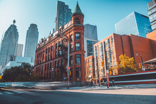 Historical Urban Oasis: An captivating image showcasing a classic brick building set amid a backdrop of sleek, modern skyscrapers, a perfect contrast of old and new in an bustling urban environment.